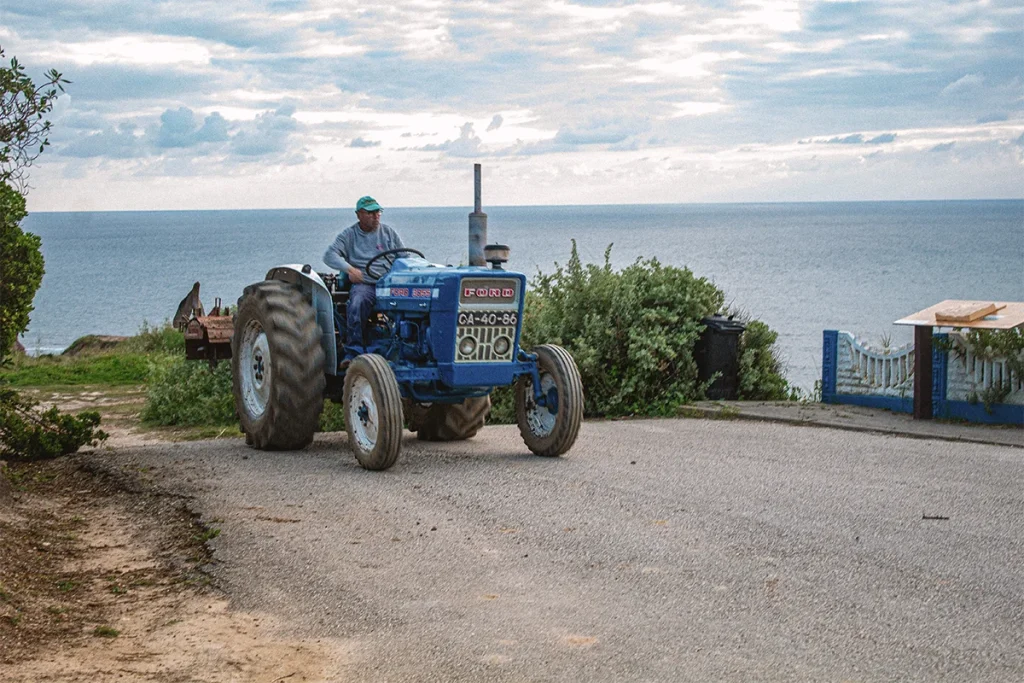 Blue Ford tractor by the sea