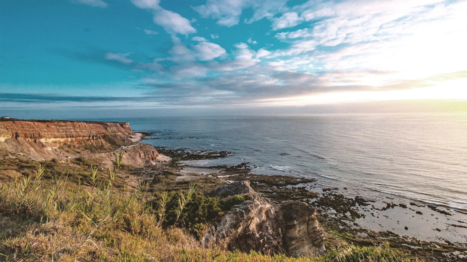 Coastal cliffs overlooking ocean at sunrise