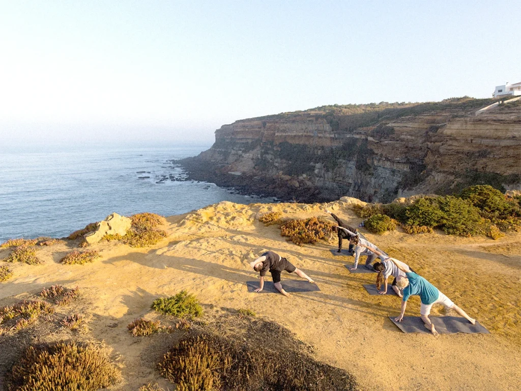 Yoga class on a cliff overlooking the ocean